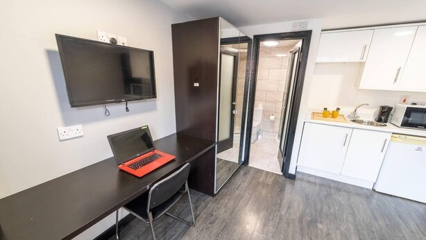 A modern kitchen with white cabinets, a microwave, and a sink. - Modern Studio next to University of Birmingham (Birmingham)