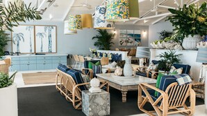 A modern interior with wicker furniture, a marble coffee table, and tropical-themed decor. - Barrenjoey House  (Palm Beach)
