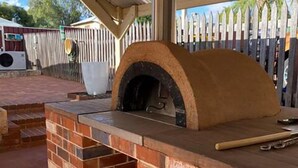 An outdoor brick pizza oven with a chimney, under a covered patio area. - Avon Homestay (Northam)