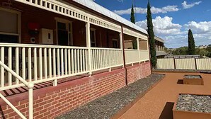 A building with a covered porch and a brick facade. - Avon Homestay (Northam)