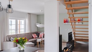 Een moderne woonkamer met een bank, een salontafel en een trap.