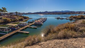 A marina with boats docked, a dock extending into calm water, and a mountainous backdrop. - Island Getaway• Patio View• Boat Ramp & Slips • Pets (Lake Havasu City)