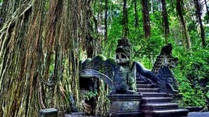 Eine steinerne Statue eines Fabelwesens in einer Waldlandschaft.