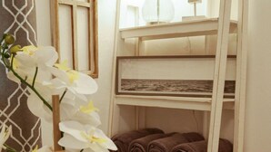 Hotelkamer met een glazen tafel, een potorkidee, een houten ladder en een raam met uitzicht.