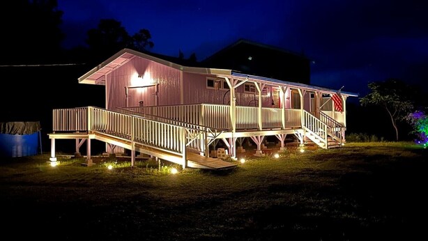 A two-story house with a porch and a covered area, illuminated at night. - Entire Place & King Sized Bed (Mountain View)