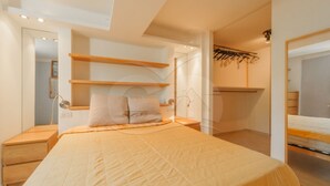 A bedroom with a bed, bedside tables, a wardrobe, and a mirror. - Modern Casa Lula with double bathroom, garden and terrace immersed in the greenery of Marina di Camp (Campo nell'Elba)