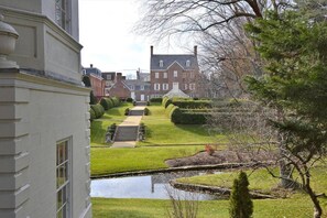 Stroll through the beautifully manicured garden, featuring a serene pond and a majestic pine tree.