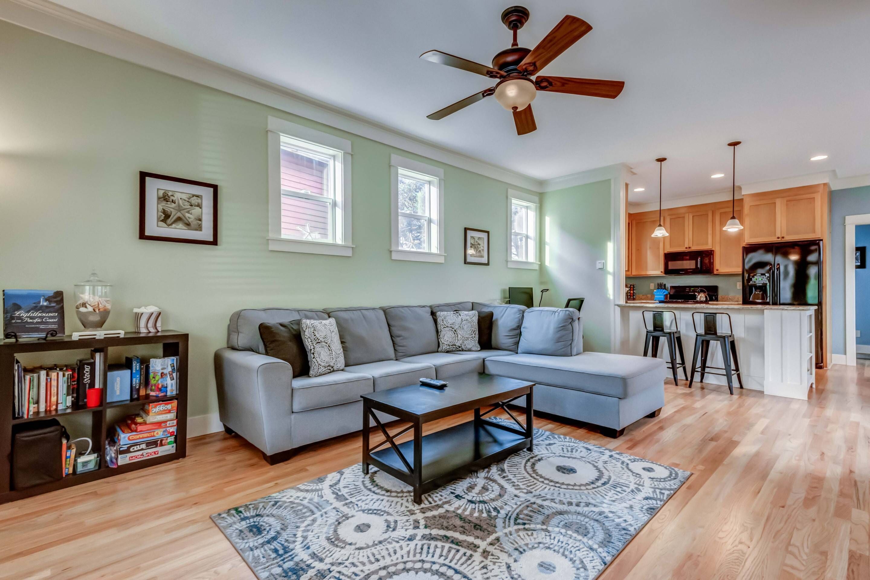 A modern living room with a sectional sofa, a coffee table, and a bookshelf.