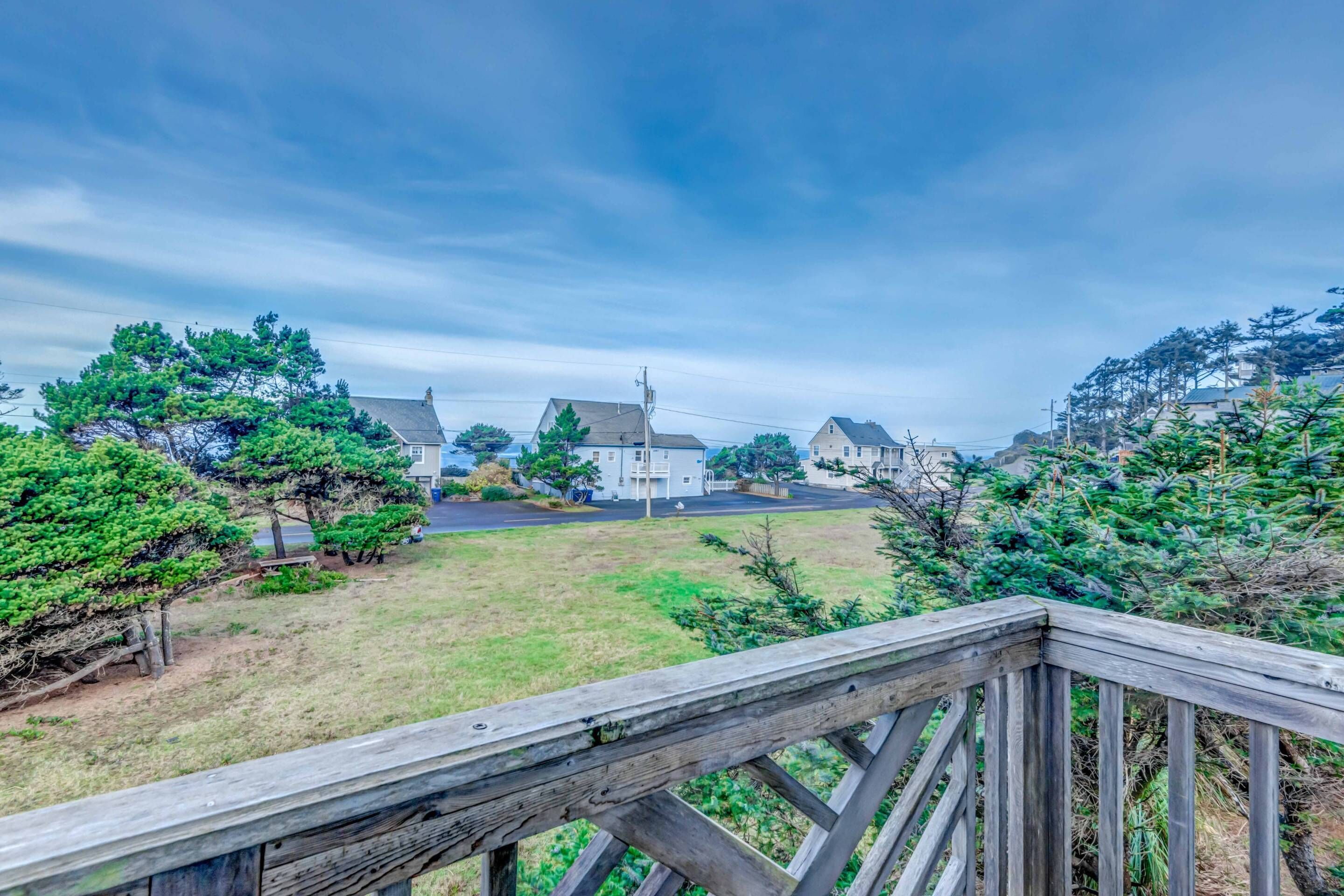 Un quartier résidentiel avec des maisons, une pelouse verdoyante et une terrasse en bois.
