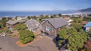 A residential area with houses, a driveway, and a view of the ocean.