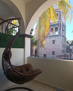 A hanging chair in a room with a view of a historic building. - Suites Santo Cielo (Loreto)