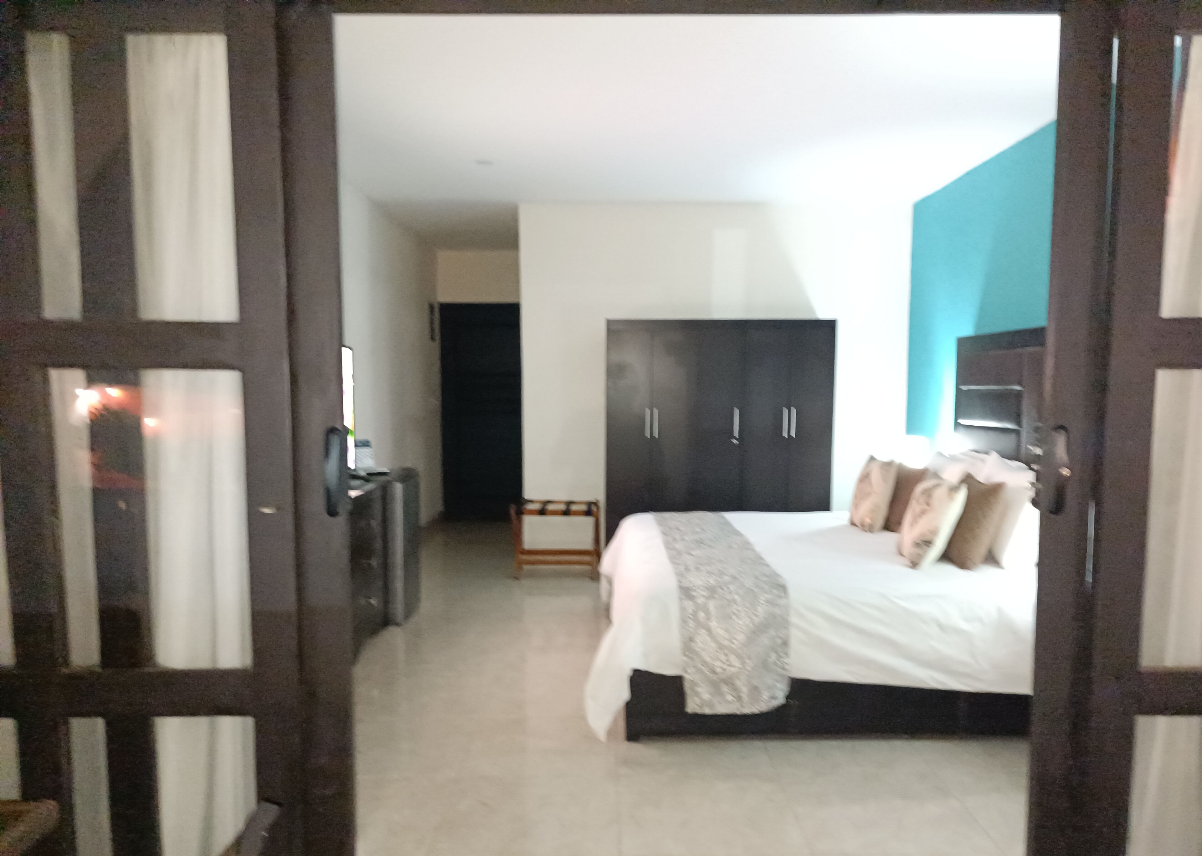 Een slaapkamer met een bed, een kledingkast, een bureau en een stoel.