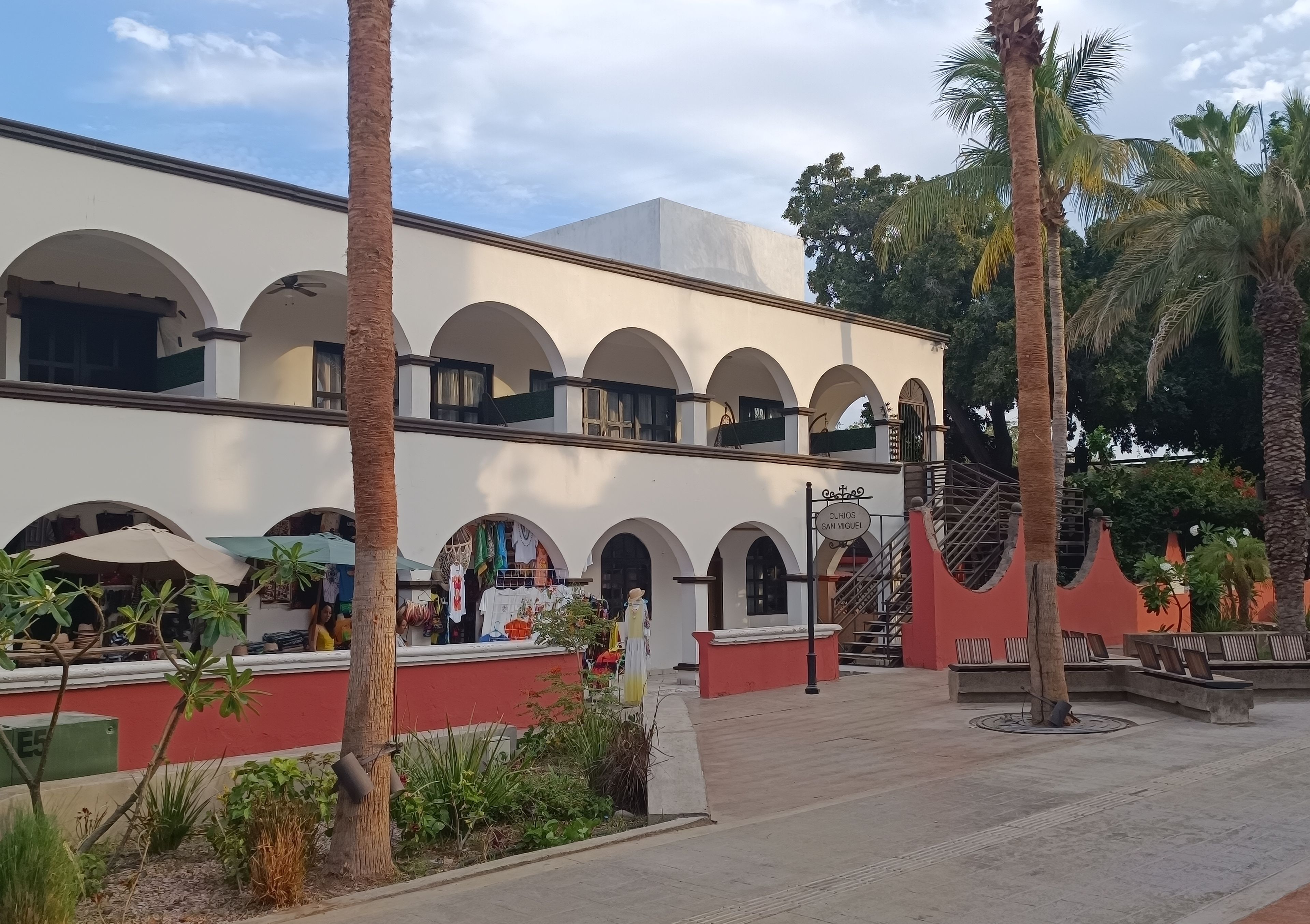 Um edifício com várias arcadas e uma placa com a inscrição 'Curios San Miguel'.