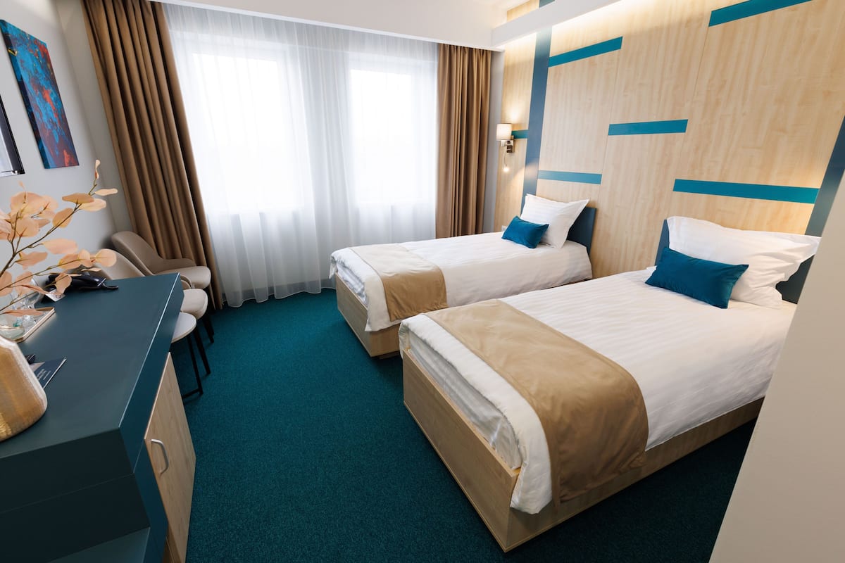 Una habitación de hotel con dos camas, un escritorio y una silla.