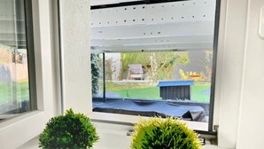 A window with two potted plants on a windowsill. - 2 room apartment, comfortable, king size bed, TV (Hannover)