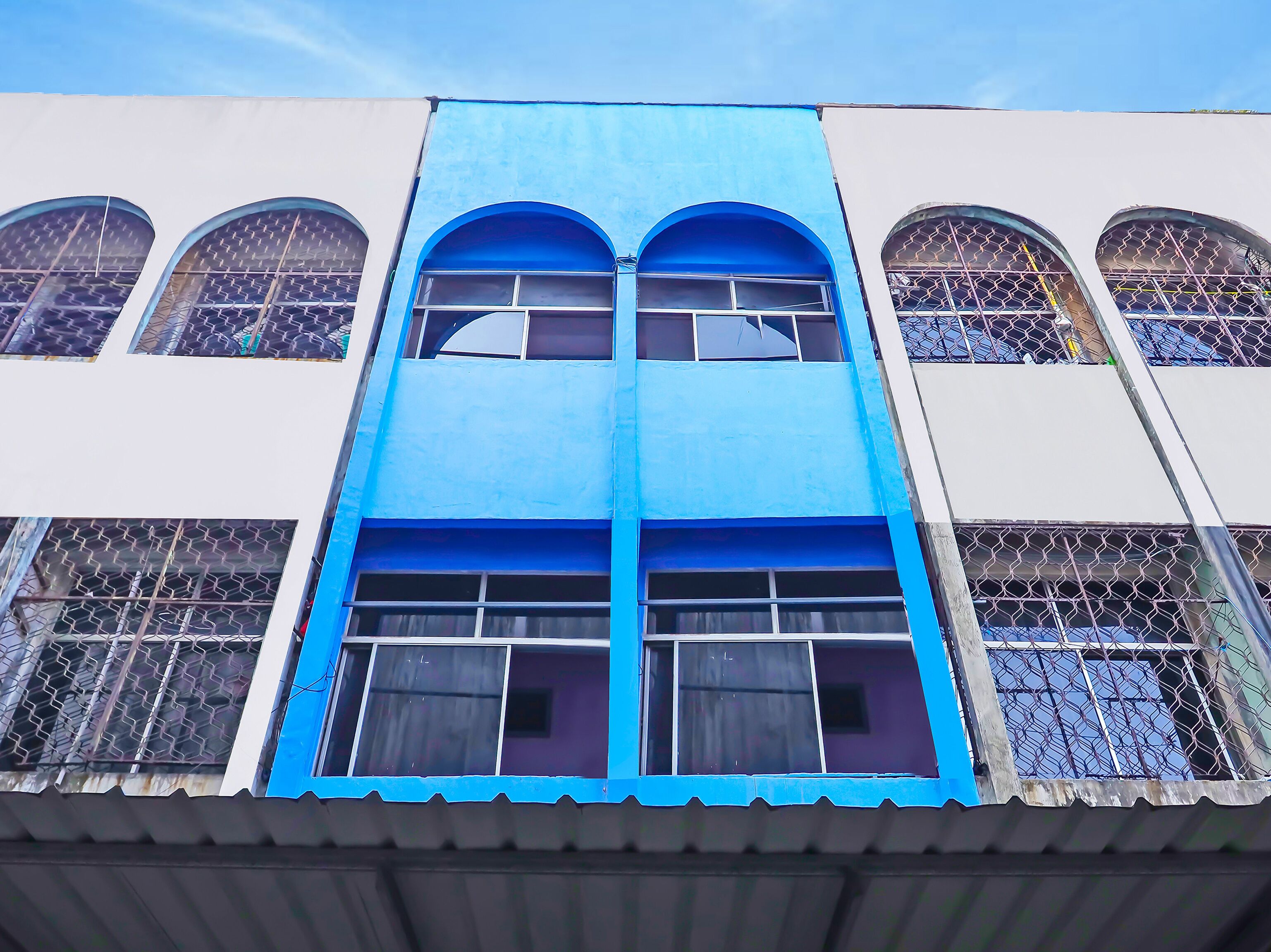 A building with multiple arched windows and a central blue section.