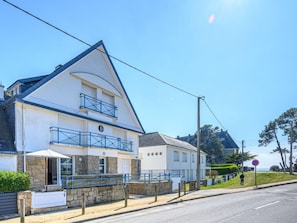 Ein zweistöckiges Gebäude mit einem Balkon, einem Steinfundament und freiem Blick auf das Meer.
