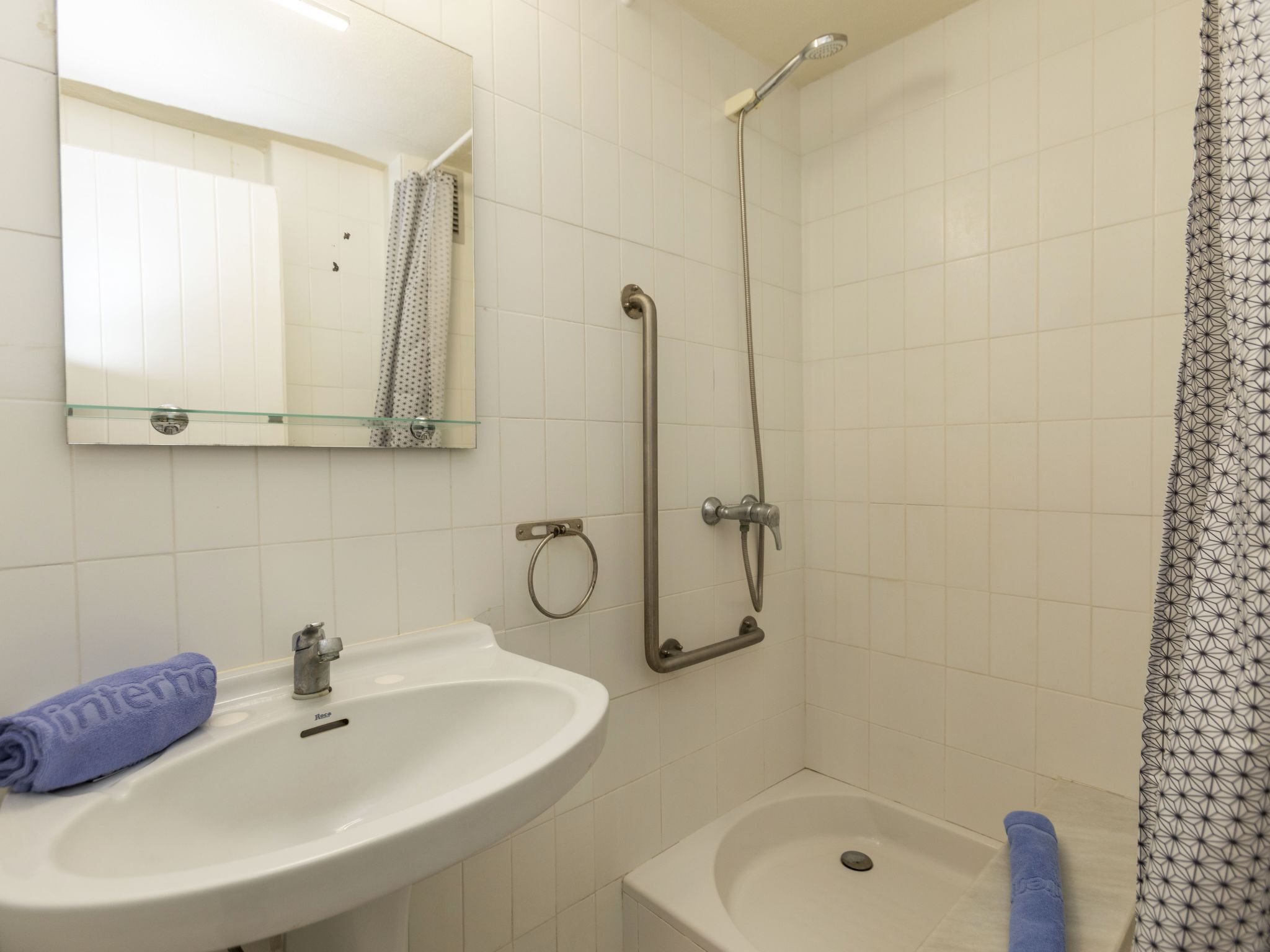 Un baño con lavabo, espejo, ducha y bañera.