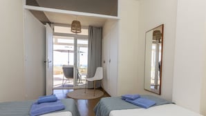 A hotel room with two beds, a round rug, a chair, and a view of the outdoors. - Paradise beach by Interhome (Pals)