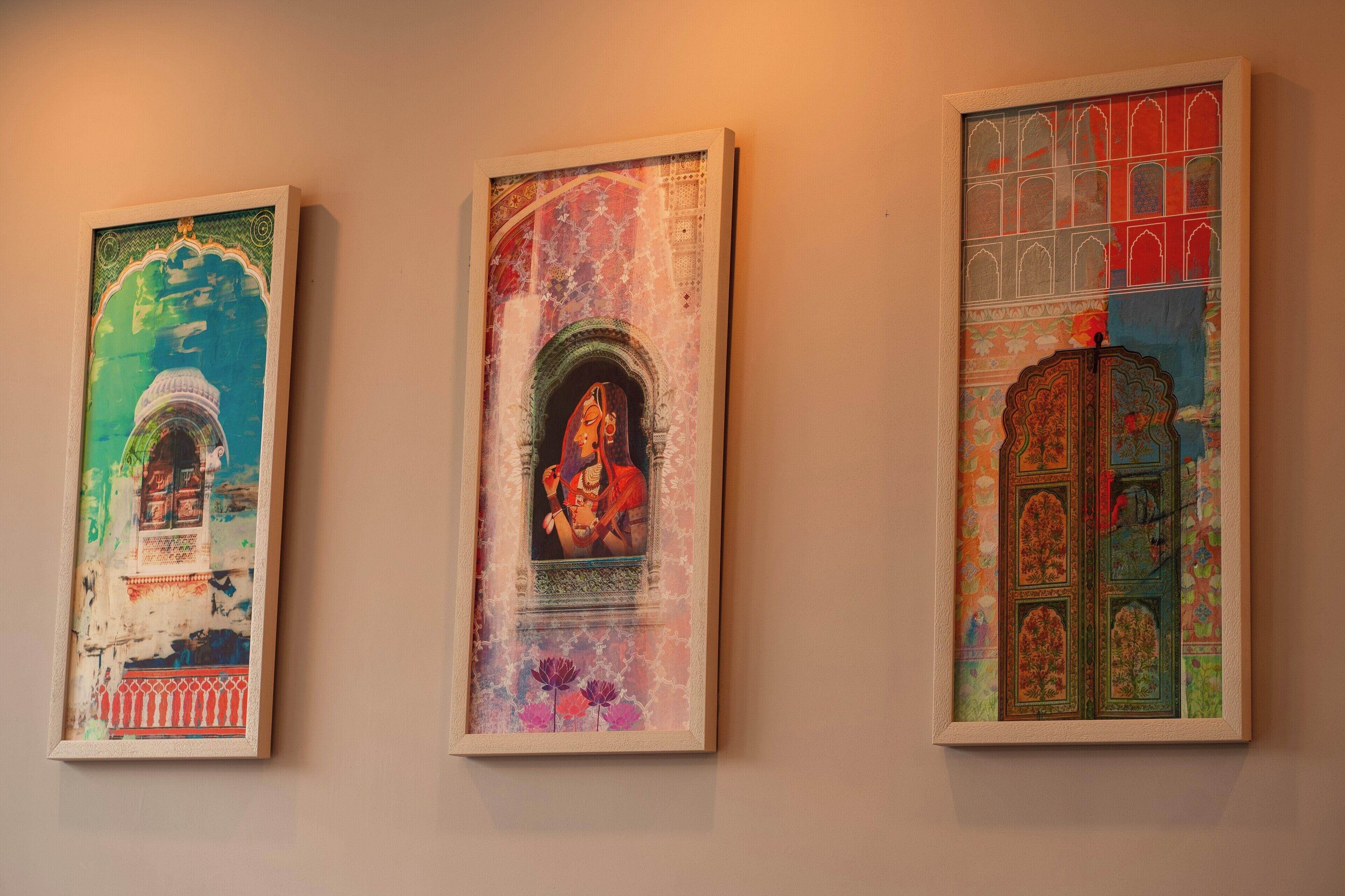 Drei gerahmte Kunstwerke an einer Wand.