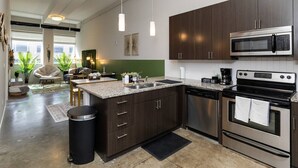 Una cocina moderna con armarios oscuros, electrodomésticos de acero inoxidable y una isla central.