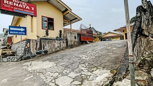 A street leading to Hotel Renata 1 with a sign indicating amenities like an Aula, TV, Air Panas, and Parkur Luis. - OYO 92406 Hotel Renata 1 (Getasan)