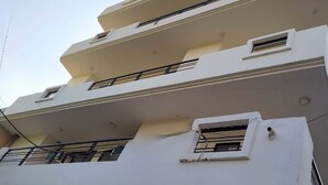 Un edificio de varios pisos con balcones, ventanas y techo plano.