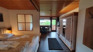 A bedroom with a bed, a desk, and a wardrobe.