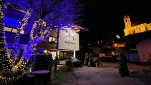 A building with a sign for Mountain Resort, surrounded by trees decorated with blue lights.
