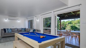 A pool table in a modern living room with a sofa and a dining area with chairs. - San Lameer Villa 3309 (Southbroom)