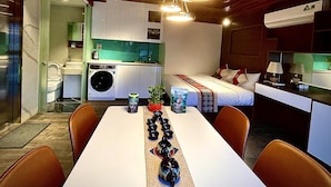 A compact hotel room with a kitchenette, a dining area, and a bed. - Maison Mackeno (Hanoi)