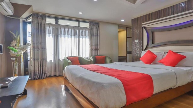 Une chambre d’hôtel avec un grand lit, une table de chevet, une chaise et un bureau.