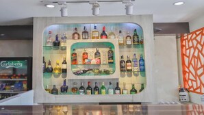 Un espace bar où une variété de bouteilles d’alcool sont exposées sur des étagères.