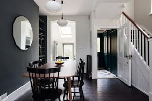 Enjoy meals in this stylish dining area with a dining table, chairs, and a mirror.