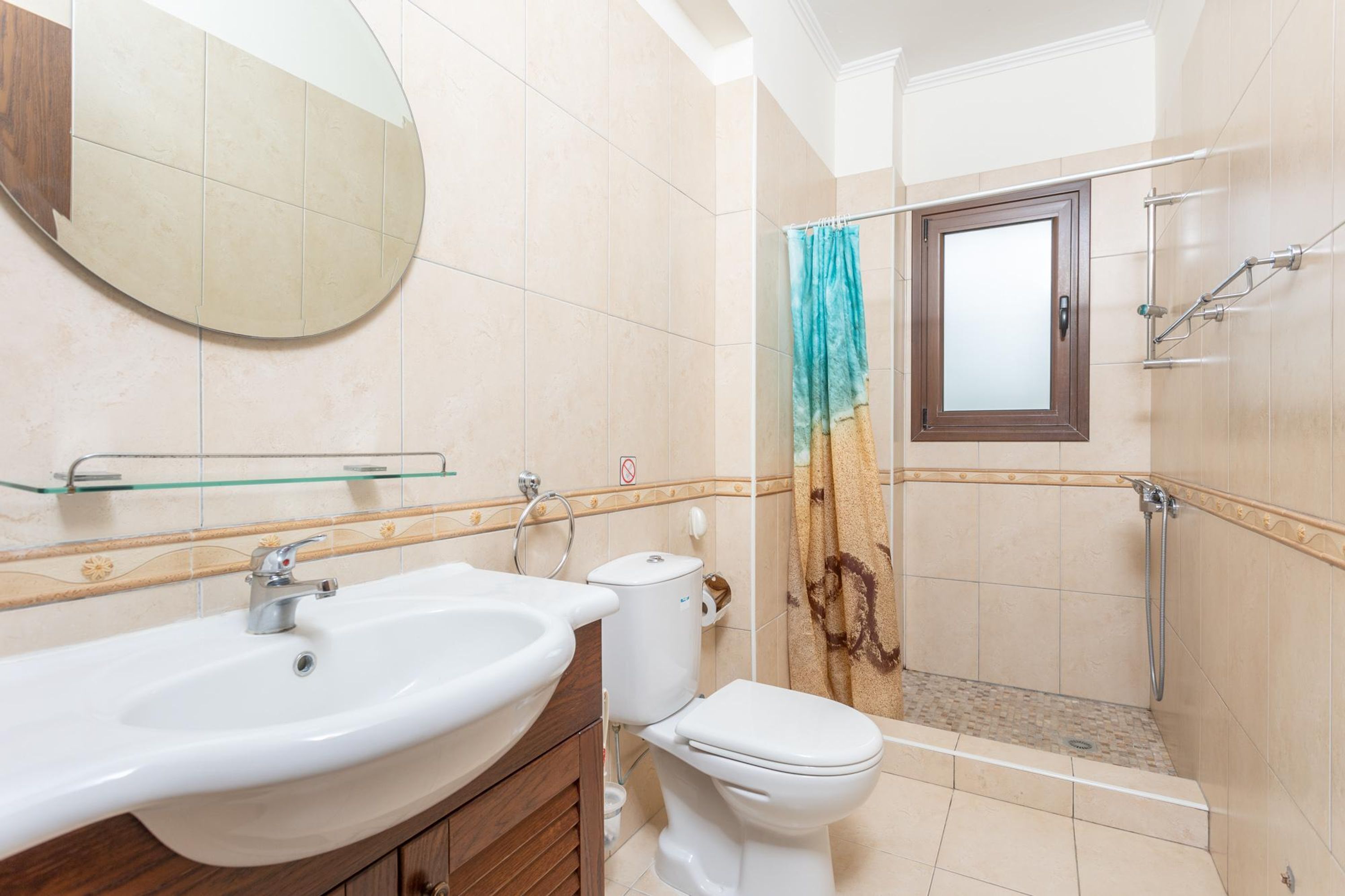 Un baño con lavamanos, inodoro y zona de ducha.