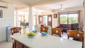 A spacious living area with a dining table set for four, a sofa, and a television. - Villa Dora in Argaka (Argaka)