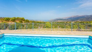 Una piscina con vistas a montañas y vegetación.