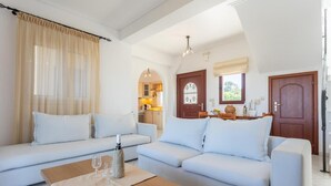 Una sala moderna con un conjunto de sofás, una mesa de centro y vistas a una cocina y comedor.
