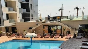 Ein Schwimmbecken mit Liegestühlen und einer Holzterrasse.