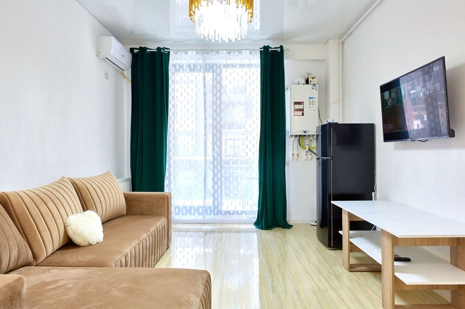 A modern living room with a sofa, a TV, and a dining table.