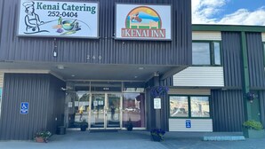 A building with signage for Kenai Catering and The Kenai Inn. - The Kenai Inn (Kenai)