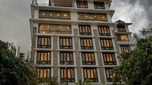 A multi-story building with a modern architectural design, featuring large windows and balconies. - Treenz Lite (Gangtok)