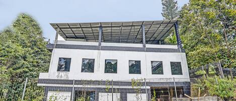 Un edificio de dos pisos con techo plano y varias ventanas.