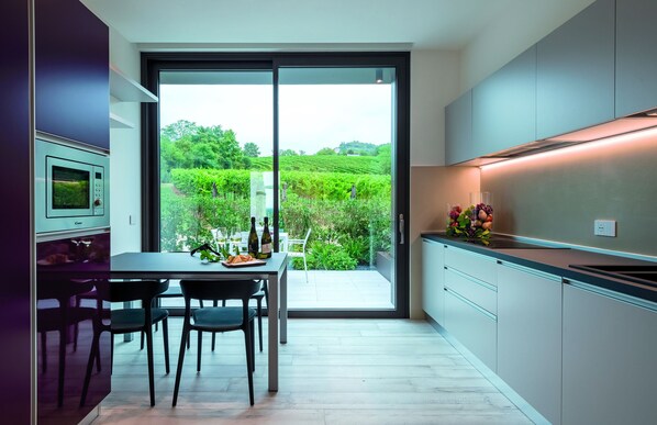 Una cocina moderna con un amplio ventanal corredero que ofrece vistas a un jardín.