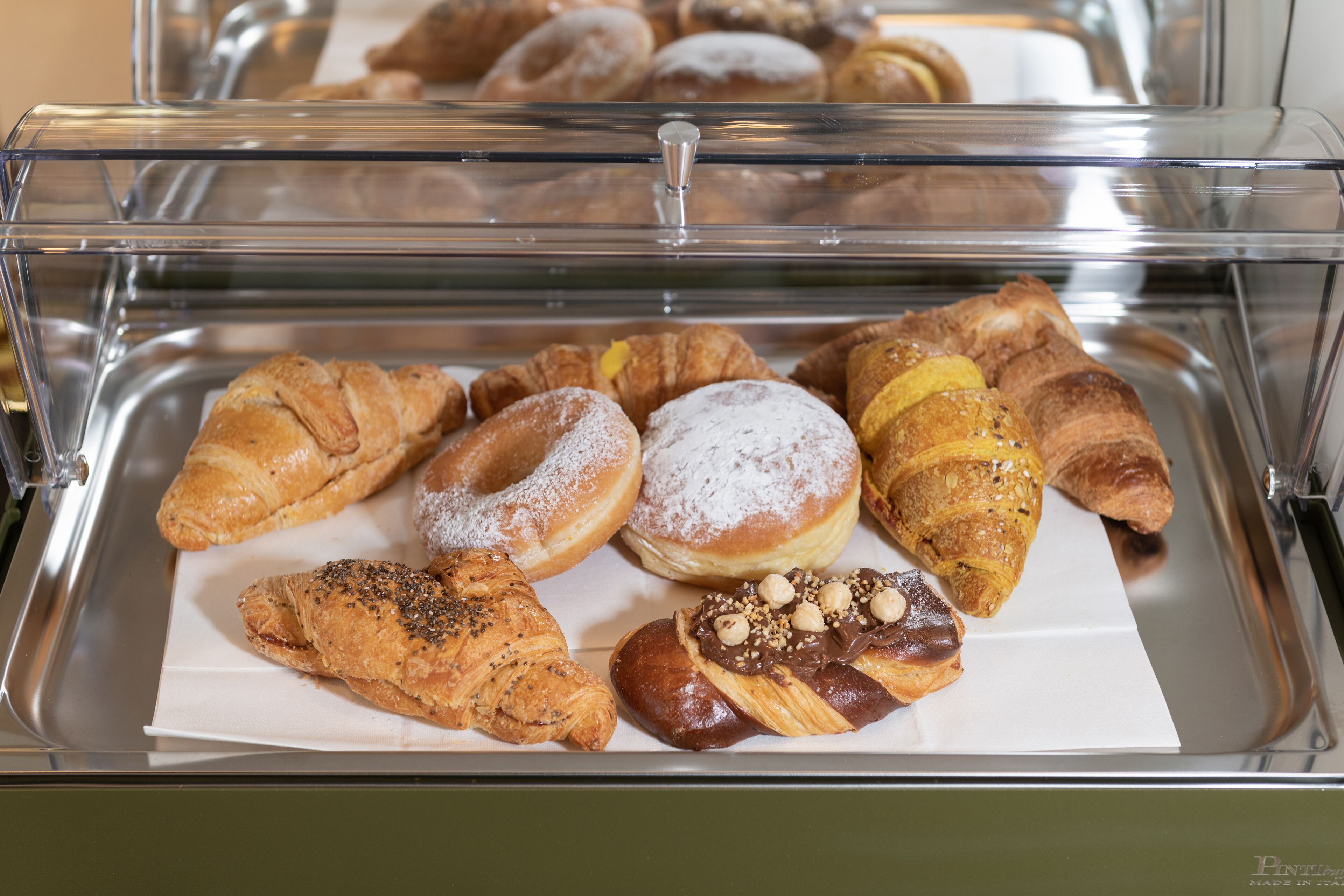 A display case with various pastries and baked goods.