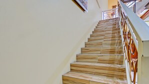 A staircase with wooden steps and a metal railing. - Hotel O Raffa Residence Syariah (Surabaya)