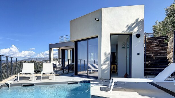 A modern pool area with clear blue water, white lounge chairs, and a view of the mountains. - Villa panoramic sea view, heated pool, Monticello, 4 bedrooms (Monticello)