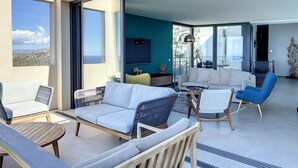 A modern living room with a sofa, chairs, and a coffee table. There is a large window with a view of the city. - Villa panoramic sea view, heated pool, Monticello, 4 bedrooms (Monticello)