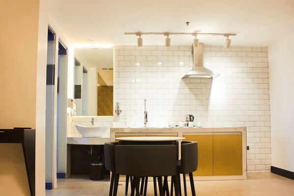 A modern kitchen with a white tiled backsplash, a central island, and a built-in oven.