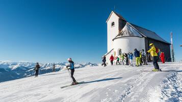 A ski resort with a church-like building, a snowy slope, and skiers.